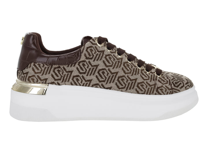 Tenis Steve Madden color marrón con estampado de monograma, suela blanca de plataforma y detalle dorado en el talón.