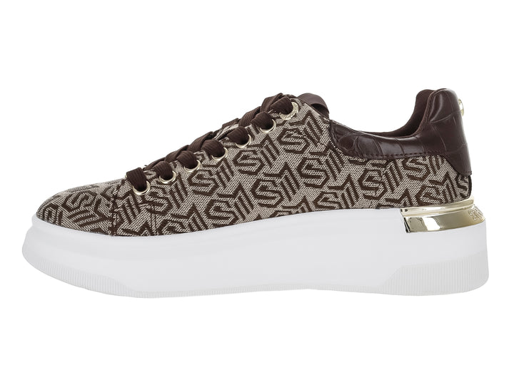 Tenis Steve Madden color marrón con estampado de monograma, suela blanca de plataforma y detalle dorado en el talón.