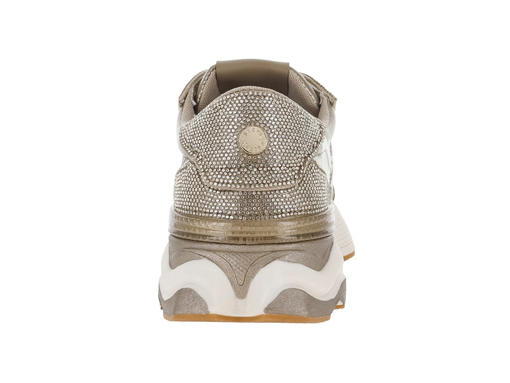 Tenis Steve Madden color dorado metálico con detalles de glitter y suela blanca ancha.