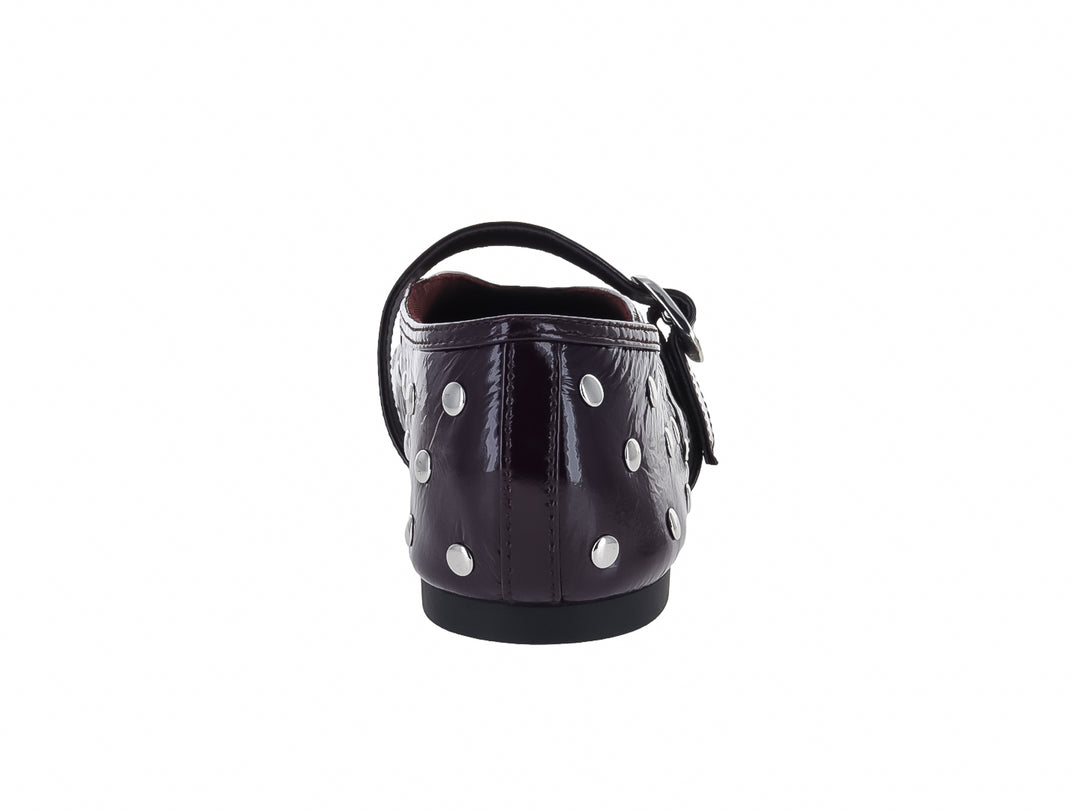 Zapato plano Steve Madden color guinda brillante con tachuelas plateadas y hebilla decorativa.