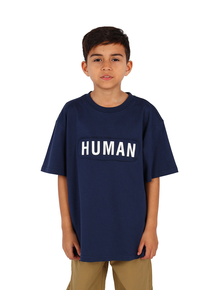 Niño vistiendo camiseta azul marino de manga corta con la palabra HUMAN impresa en letras blancas en el pecho.