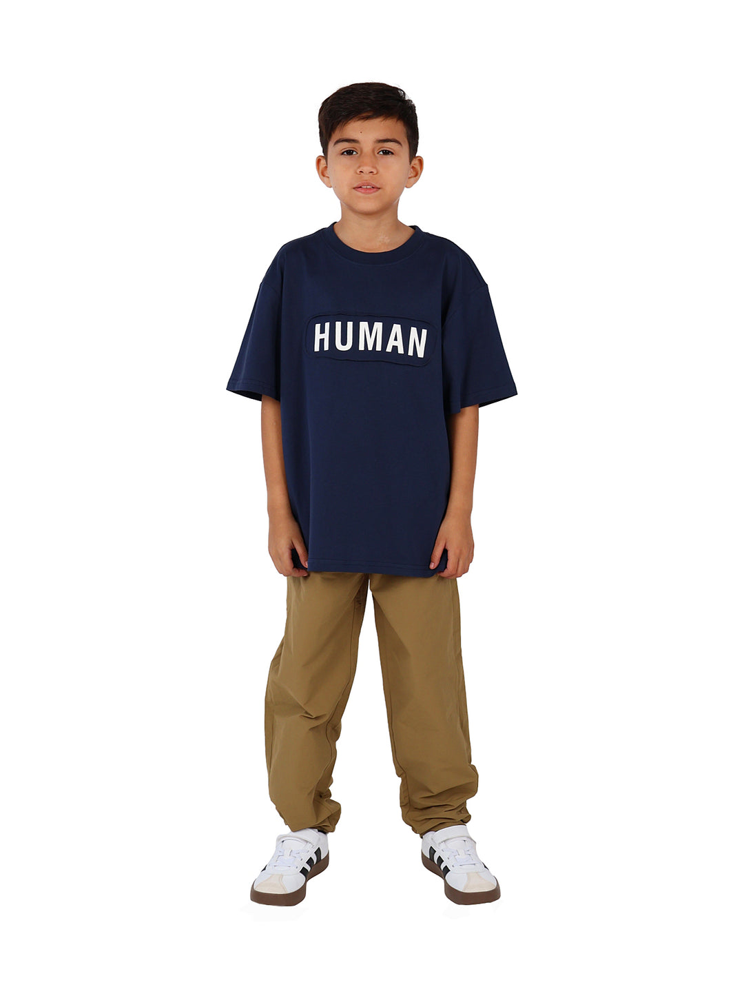 Niño vistiendo camiseta azul marino de manga corta con la palabra HUMAN impresa en letras blancas en el pecho.