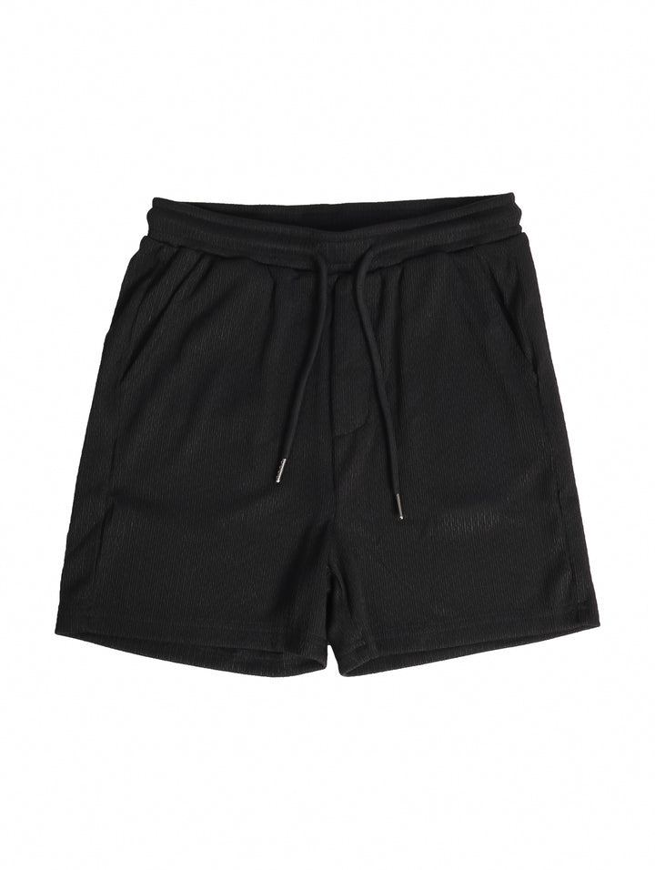 Conjunto de ropa para niño compuesto por camisa negra de manga corta y short negro a juego.