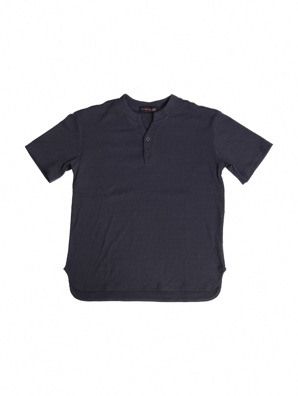 Conjunto de ropa para niño compuesto por camisa gris oscuro de manga corta y short a juego con tenis blancos.