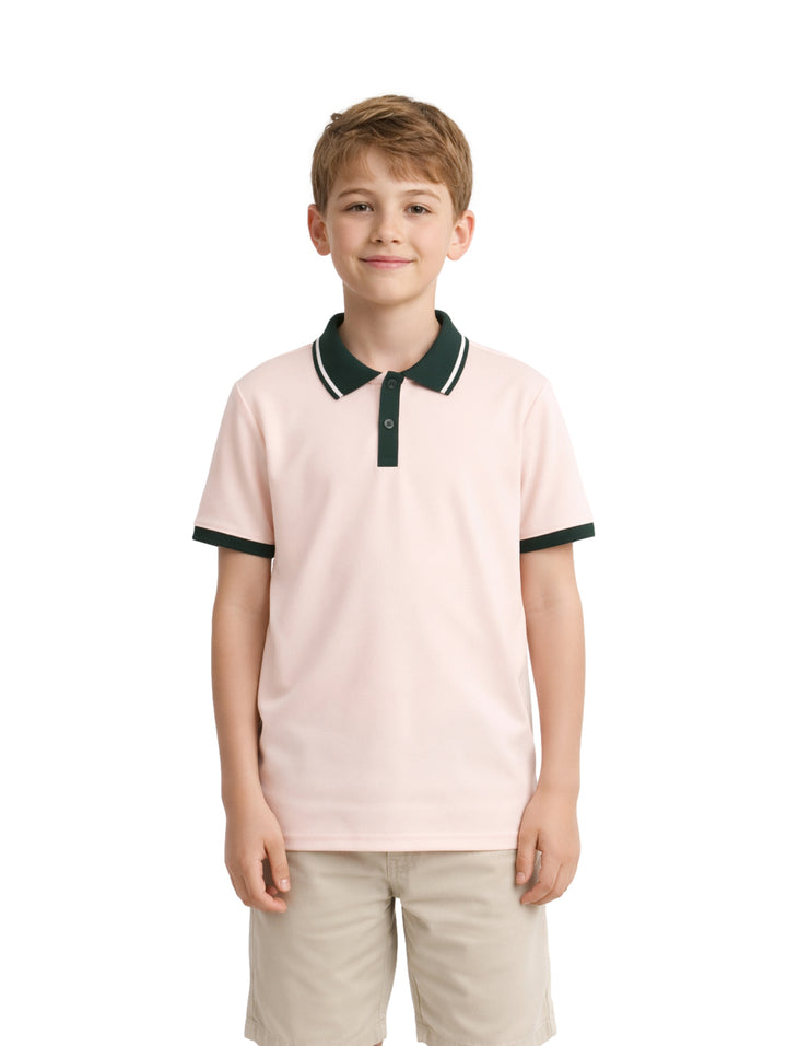 Niño vistiendo polo básica color beige con cuello y bordes de mangas en contraste verde oscuro.