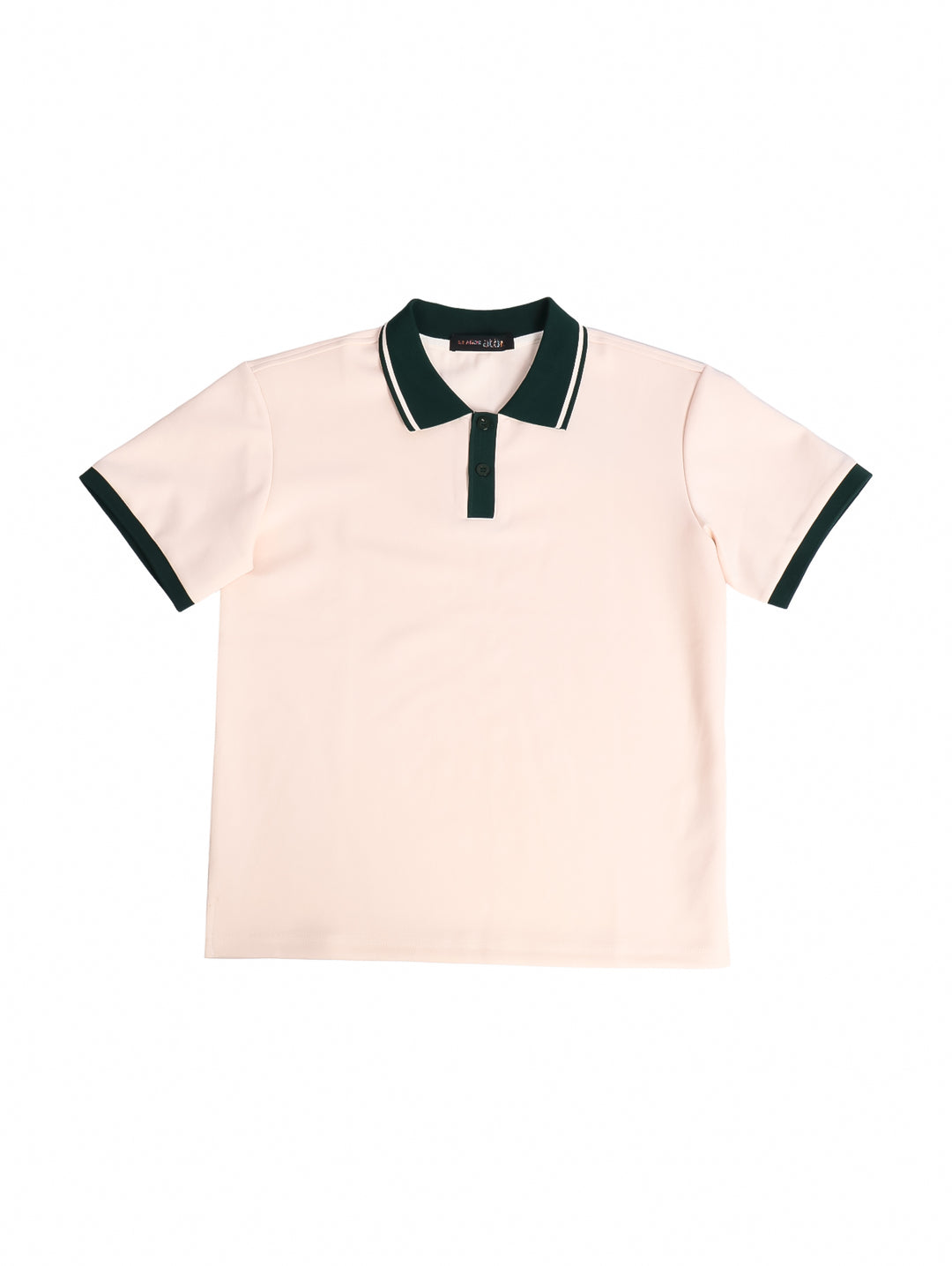 Niño vistiendo polo básica color beige con cuello y bordes de mangas en contraste verde oscuro.