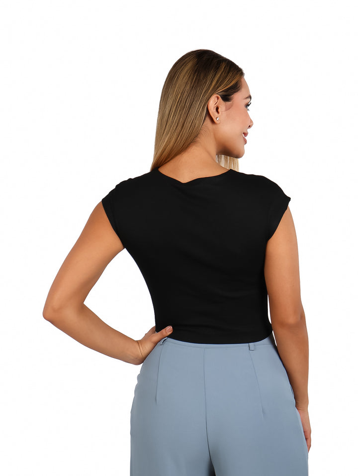 Mujer vistiendo un crop top negro de manga corta y pantalones azul claro.