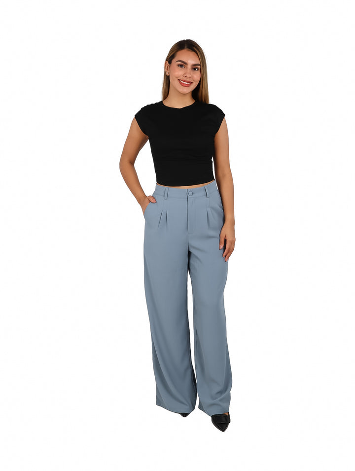 Mujer vistiendo un crop top negro de manga corta y pantalones azul claro.