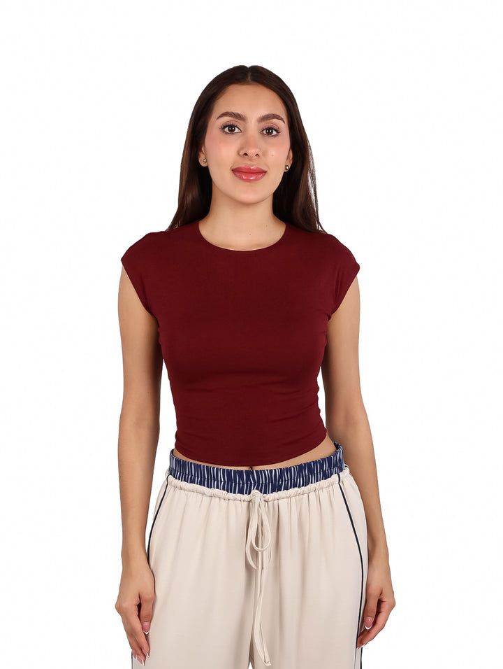 Mujer vistiendo un crop top de manga corta color burgundy de la marca ATOK.