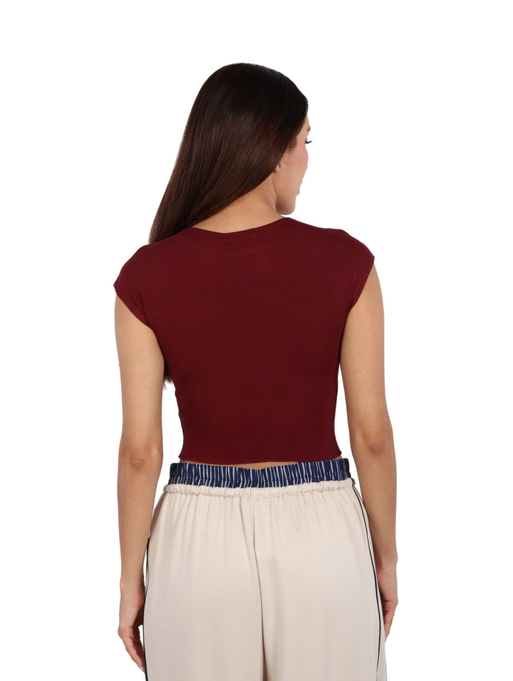 Mujer vistiendo un crop top de manga corta color burgundy de la marca ATOK.