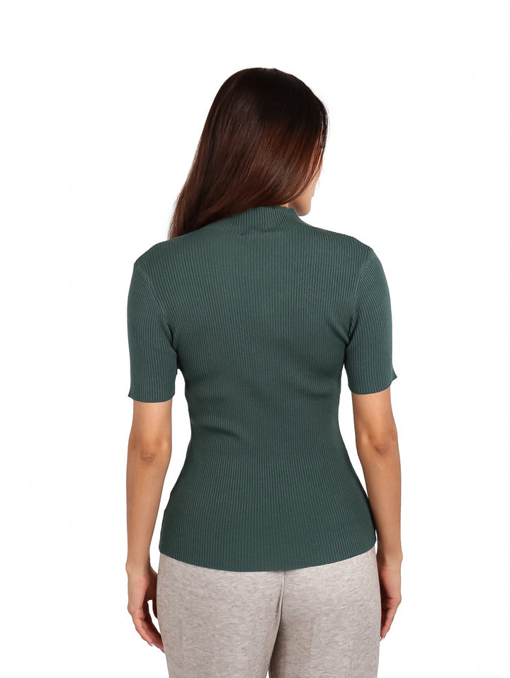 Mujer vistiendo una blusa ajustada de color azul aqua con cuello alto y manga corta.