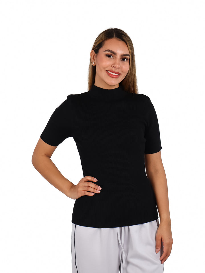 Mujer vistiendo una blusa negra de manga corta y cuello alto.