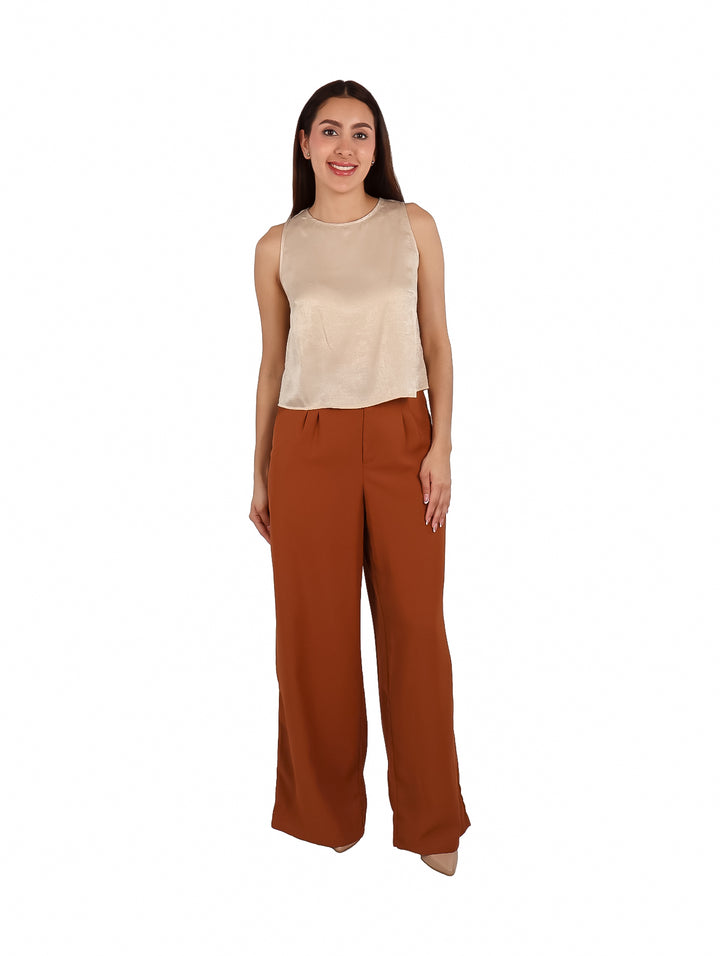 Mujer vistiendo una blusa beige sin mangas de estilo elegante.
