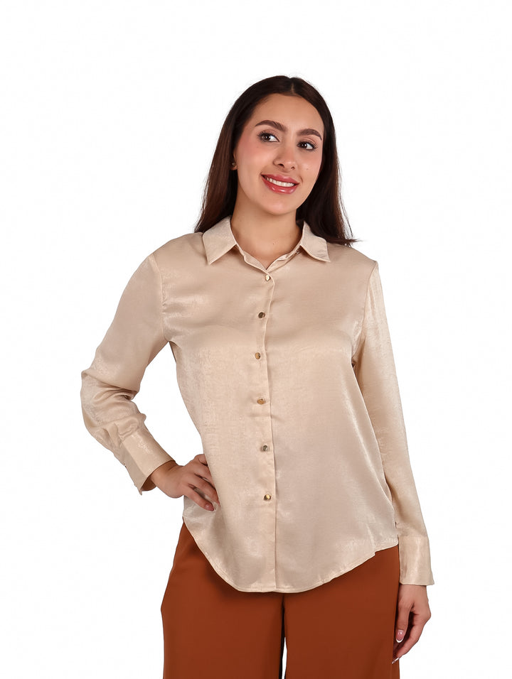 Mujer vistiendo una camisa beige de satín con botones y pantalones color café.