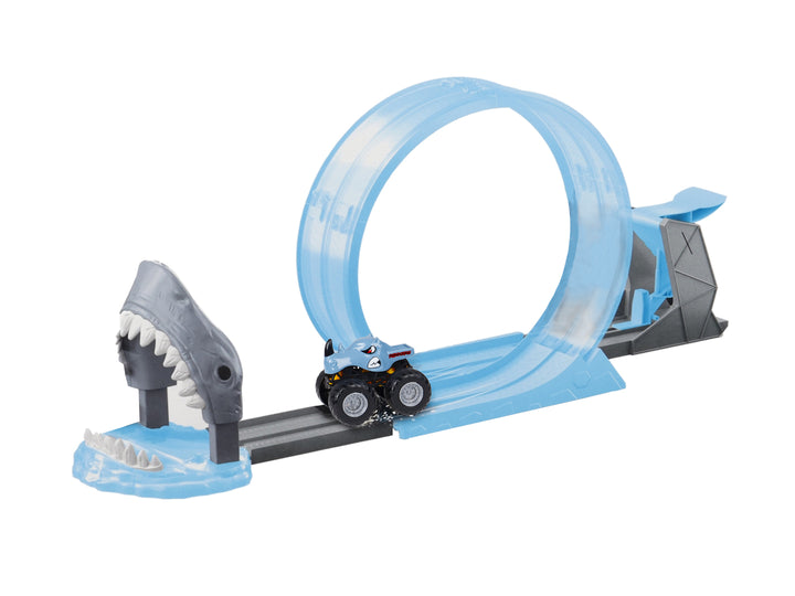 Set de pista de carreras Monster Track con loop azul, figura de tiburón gris y vehículos monster truck.