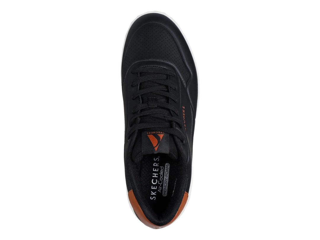 Tenis Skechers Uno Court color negro con detalles marrón y suela blanca con cámara de aire visible.
