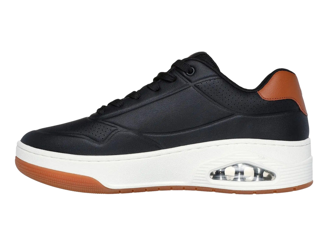 Tenis Skechers Uno Court color negro con detalles marrón y suela blanca con cámara de aire visible.