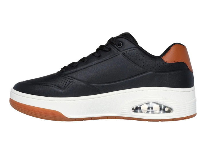 Tenis Skechers Uno Court color negro con detalles marrón y suela blanca con cámara de aire visible.