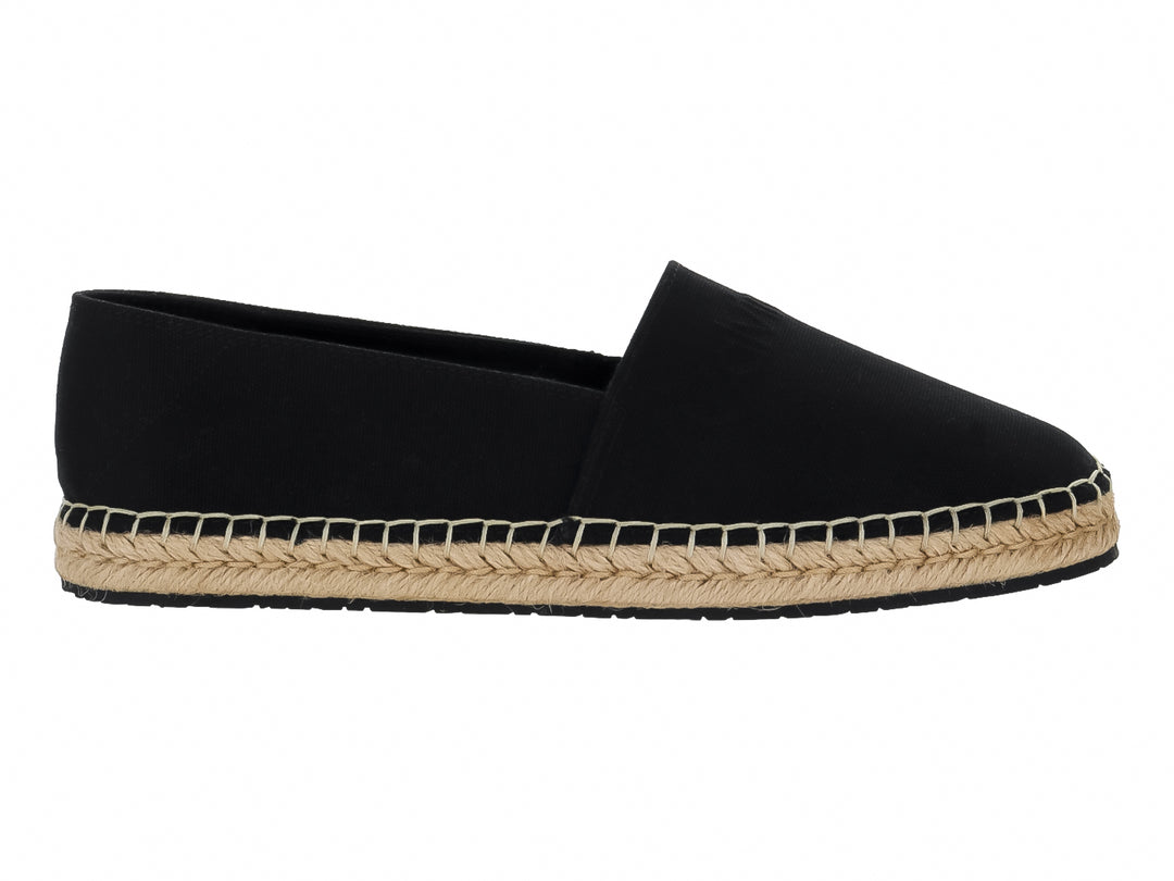 Zapato tipo alpargata color negro con suela de cuerda tejida en tono beige.