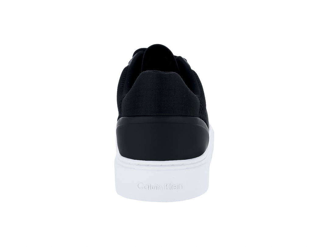 Tenis Calvin Klein color negro con suela blanca y logotipo CK blanco en el lateral.