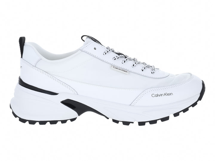 Tenis blancos Calvin Klein con detalles en negro y suela gruesa.
