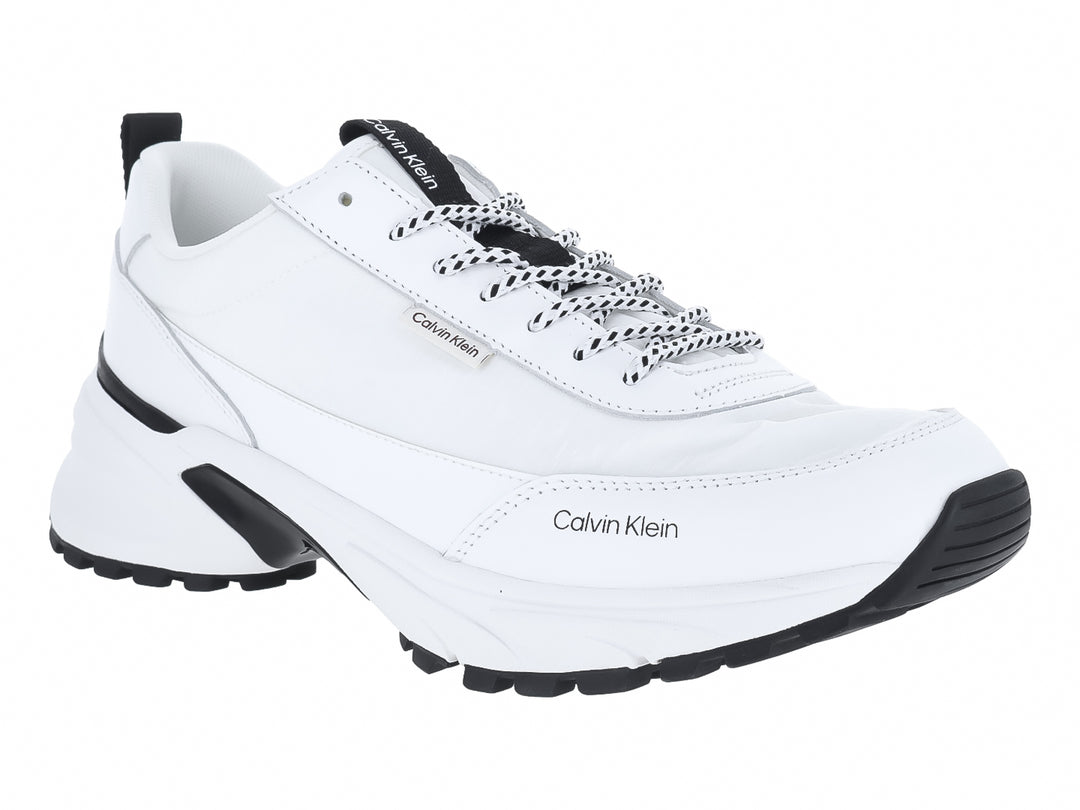 Tenis blancos Calvin Klein con detalles en negro y suela gruesa.