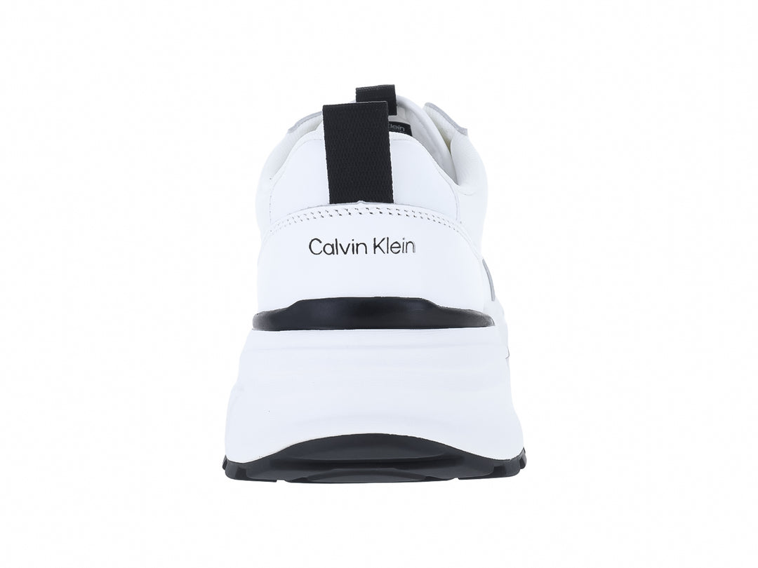 Tenis blancos Calvin Klein con detalles en negro y suela gruesa.