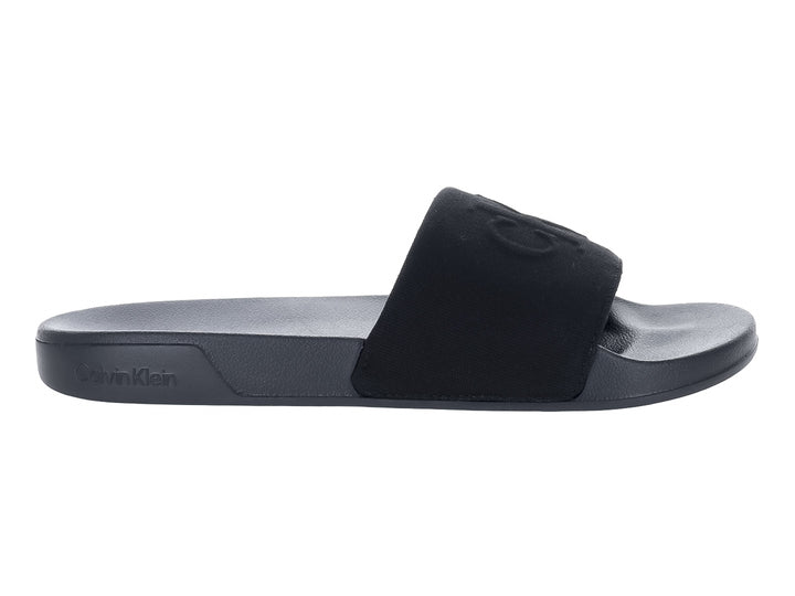 Sandalias negras Calvin Klein con correa ancha y suela plana.