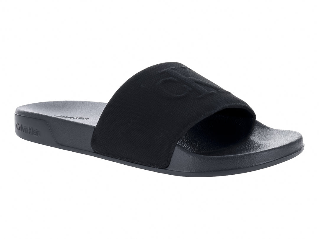 Sandalias negras Calvin Klein con correa ancha y suela plana.