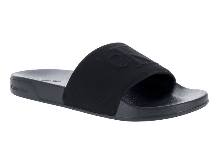 Sandalias negras Calvin Klein con correa ancha y suela plana.
