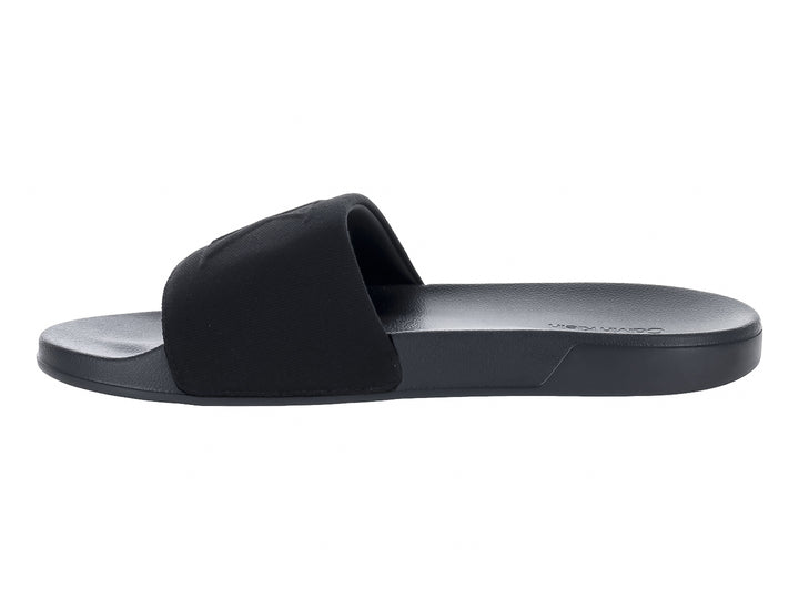 Sandalias negras Calvin Klein con correa ancha y suela plana.