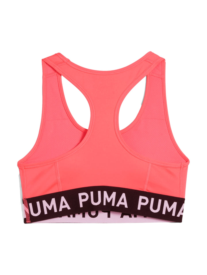 Bra deportivo PUMA color Peach Frost con banda elástica negra en la base y logo central.