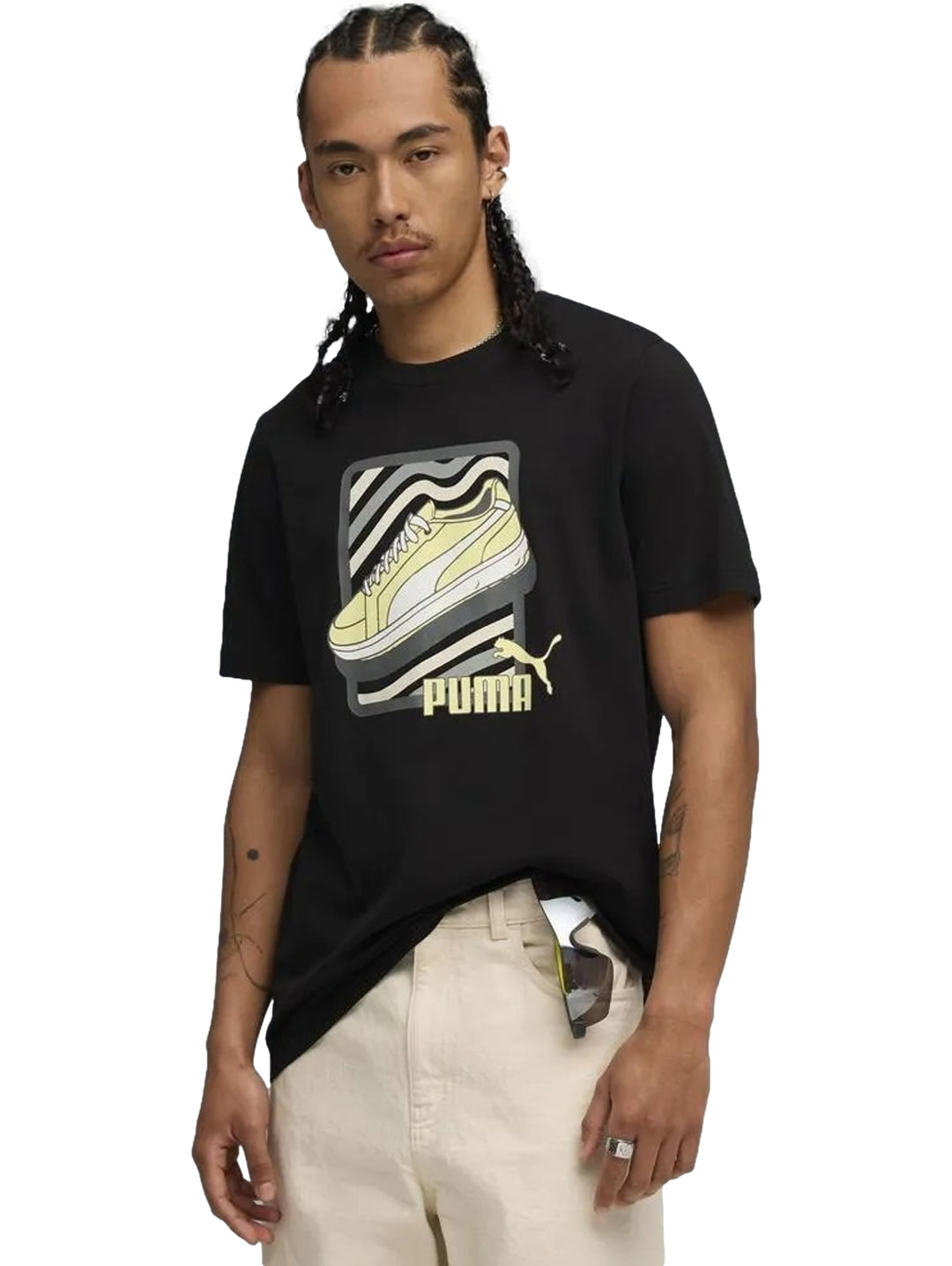 Hombre vistiendo una camiseta negra de PUMA con un gráfico de un tenis amarillo en el pecho.