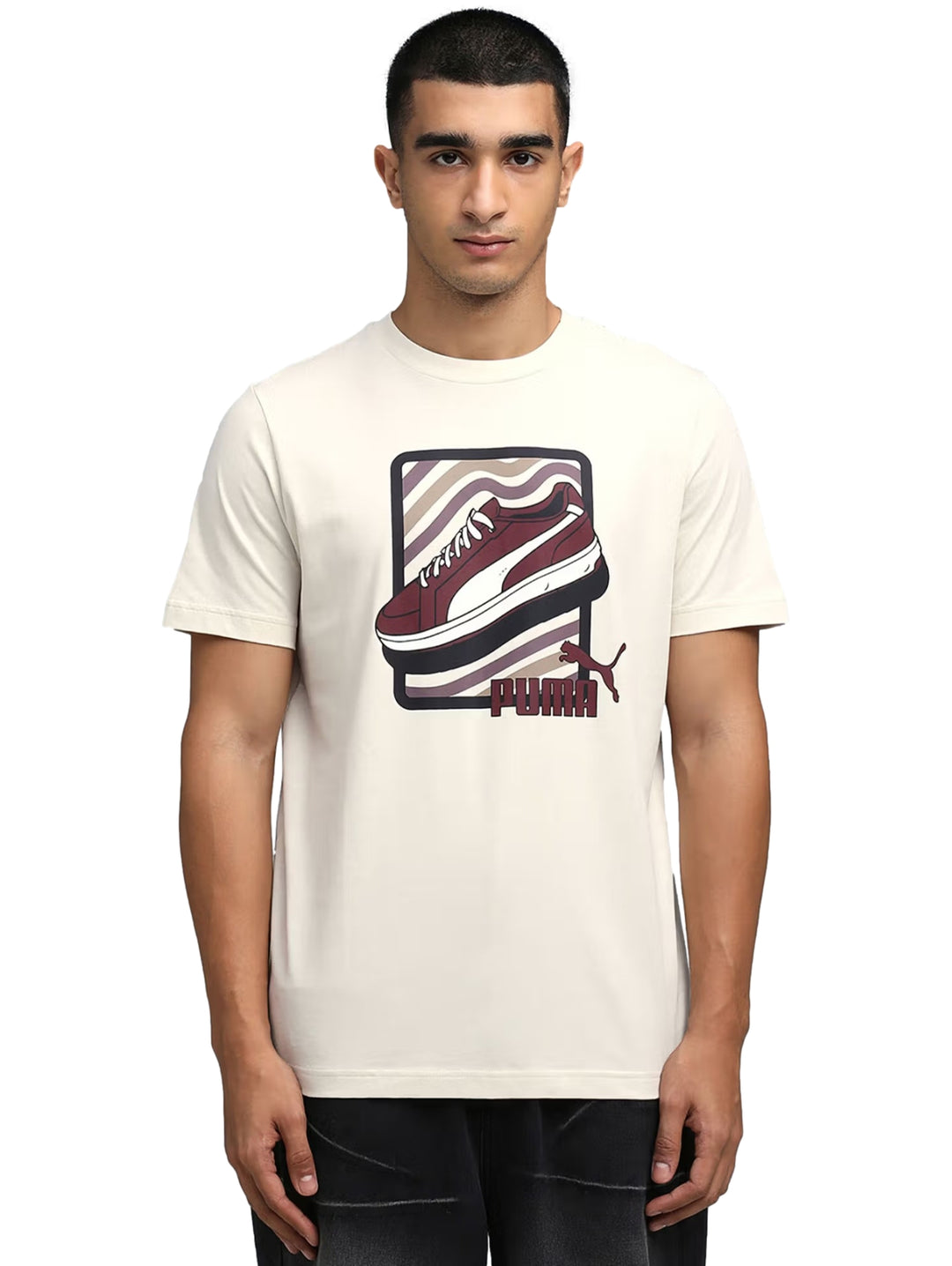 Hombre vistiendo camiseta PUMA color blanco hueso con gráfico de un tenis en el pecho.