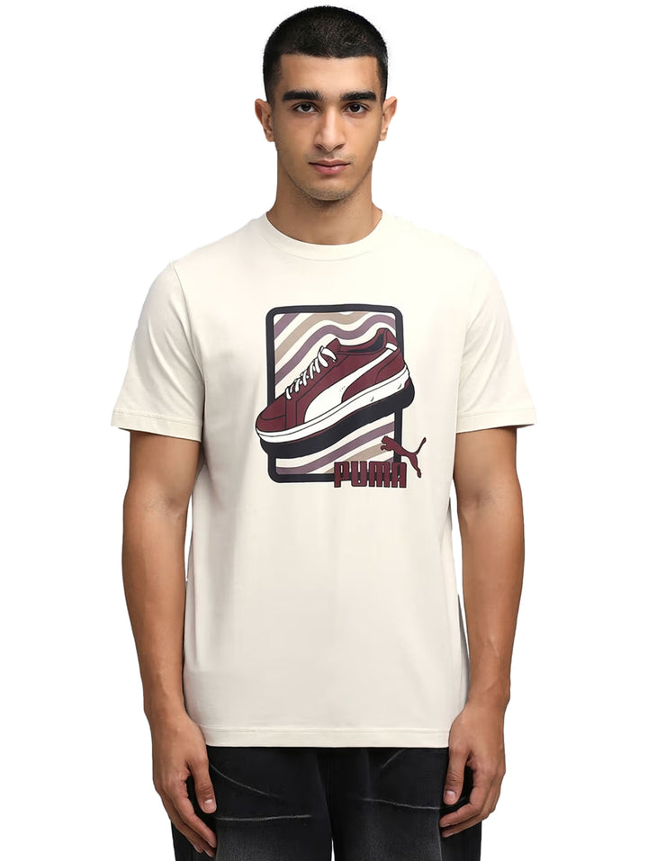Hombre vistiendo camiseta PUMA color blanco hueso con gráfico de un tenis en el pecho.