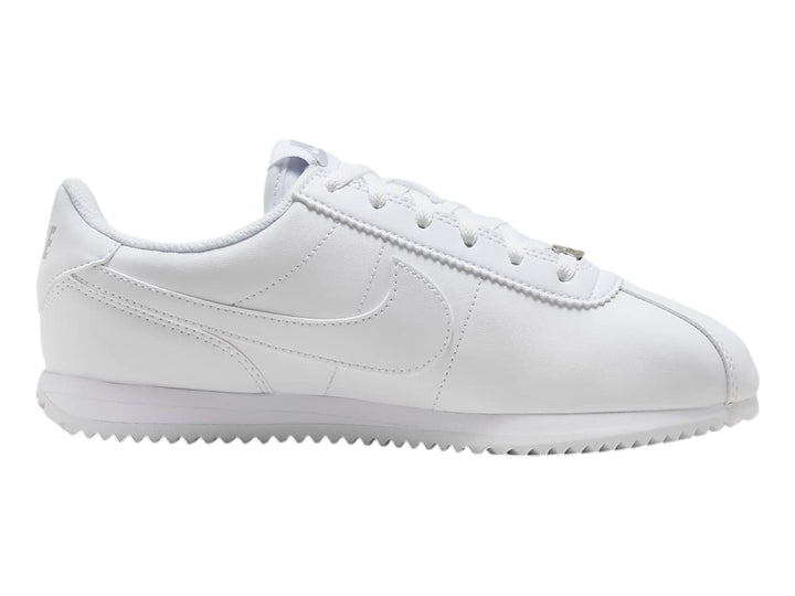 Tenis Nike Cortez blancos para niños con suela blanca y cordones.
