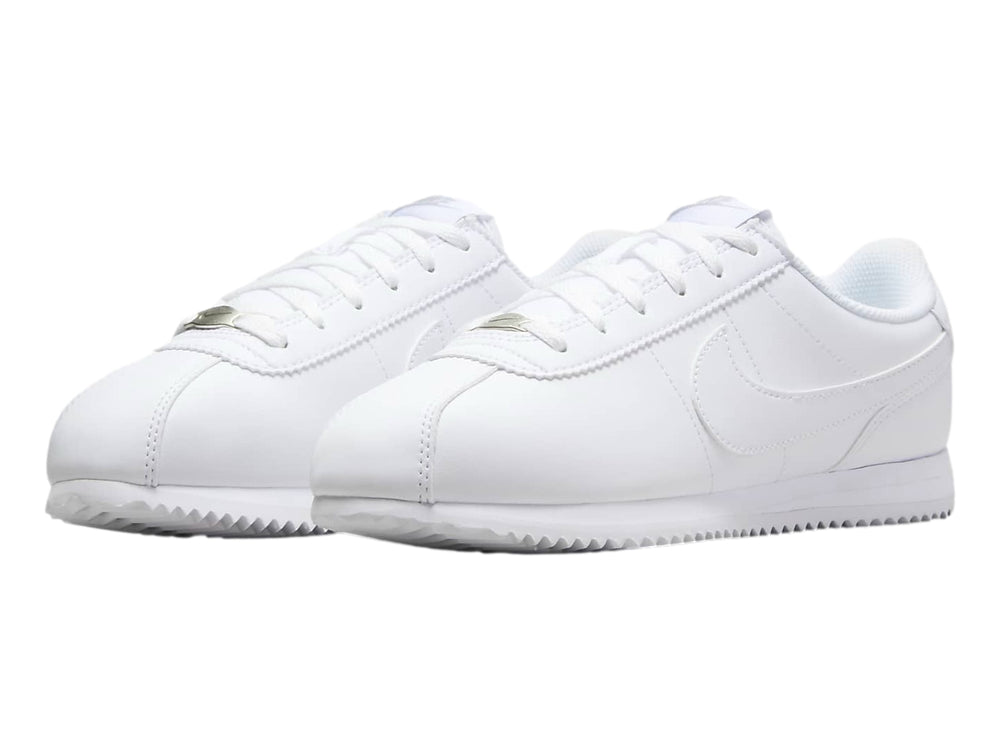 Tenis Nike Cortez blancos para niños con suela blanca y cordones.