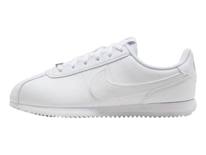 Tenis Nike Cortez blancos para niños con suela blanca y cordones.