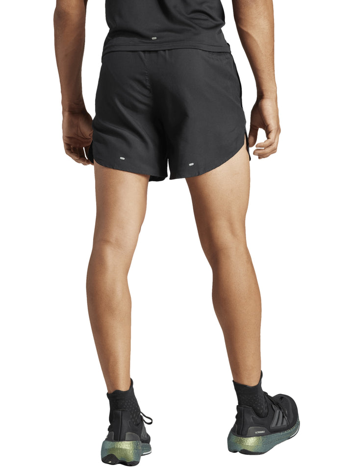 Hombre vistiendo shorts deportivos Adidas color negro para correr.