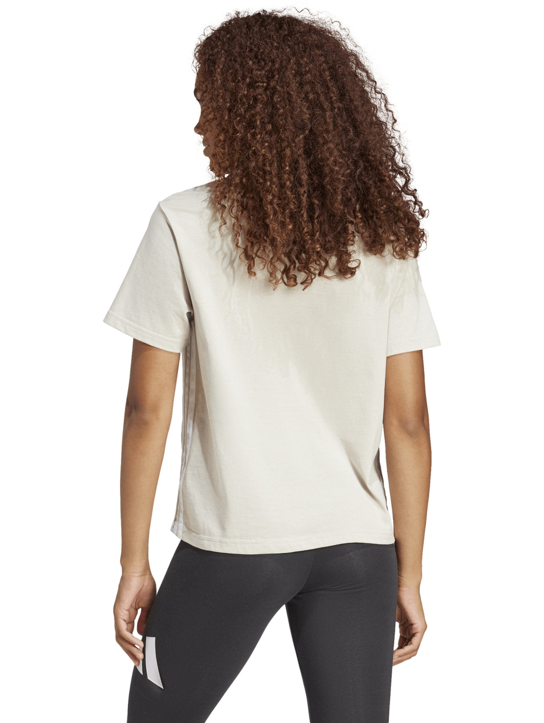 Mujer vistiendo playera Adidas color beige de manga corta y cuello redondo.