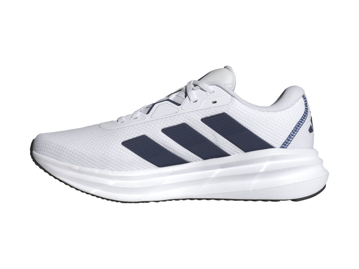 Tenis Adidas Galaxy 7 en color blanco con tres franjas azul oscuro y suela blanca amortiguada.