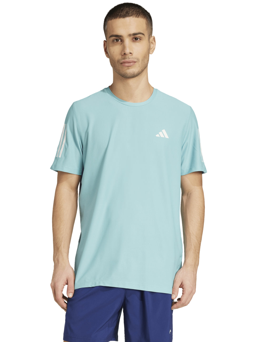 Hombre vistiendo camiseta deportiva Adidas color menta con rayas blancas en los hombros.