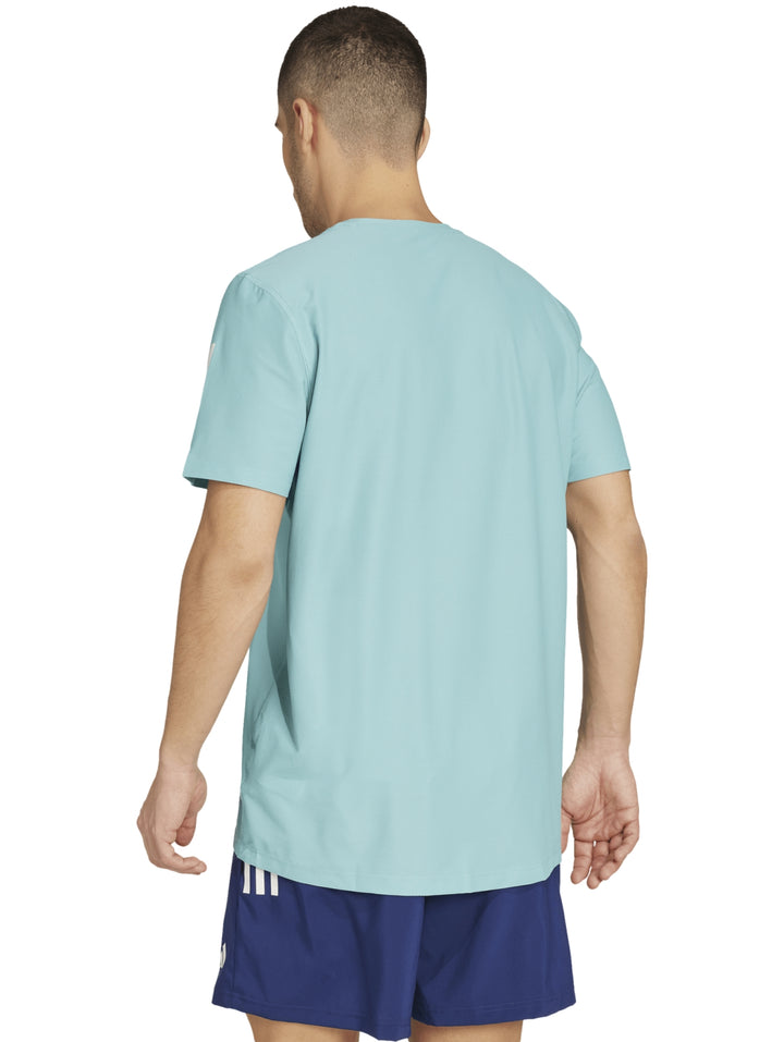 Hombre vistiendo camiseta deportiva Adidas color menta con rayas blancas en los hombros.