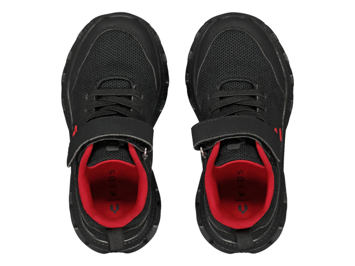 Tenis deportivos Charly color negro con detalles en rojo y cierre de velcro.