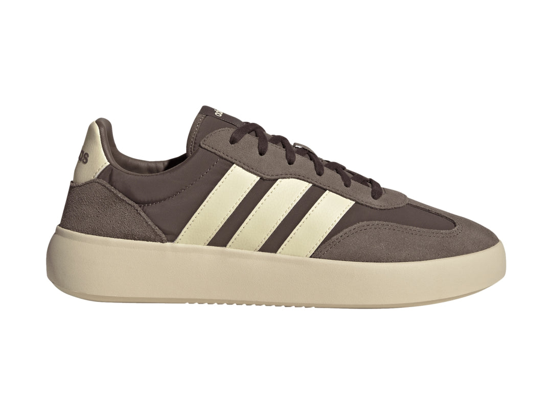 Tenis Adidas color marrón con tres franjas y suela gruesa en color crema, vista lateral.