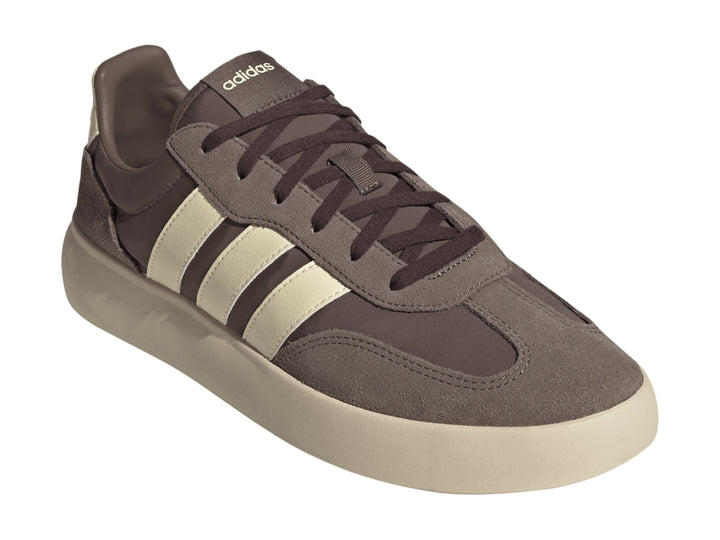 Tenis Adidas color marrón con tres franjas y suela gruesa en color crema, vista lateral.