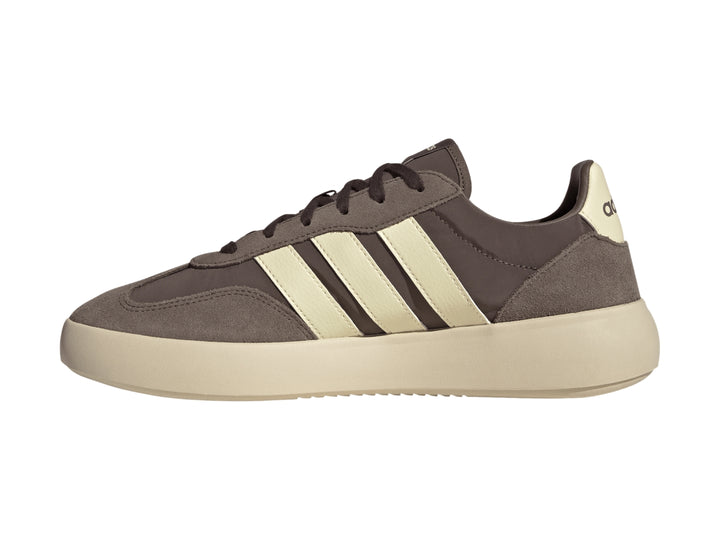 Tenis Adidas color marrón con tres franjas y suela gruesa en color crema, vista lateral.