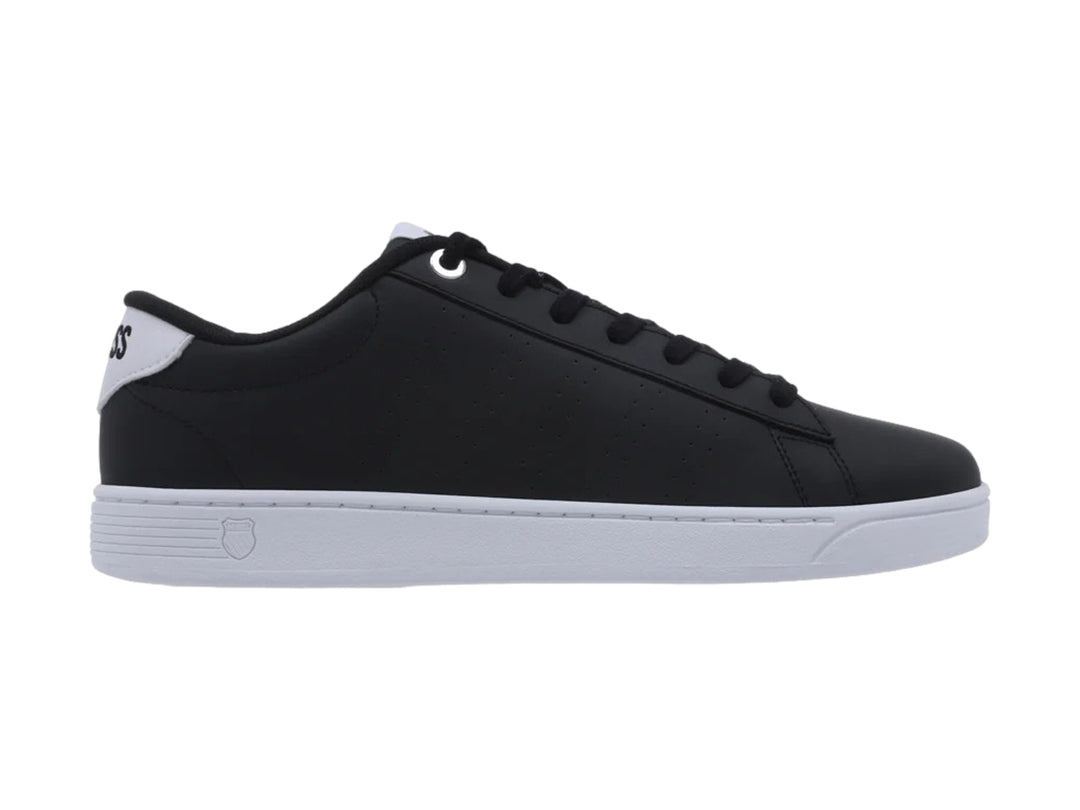 Tenis K-Swiss Base Court color negro con suela blanca y cordones negros.