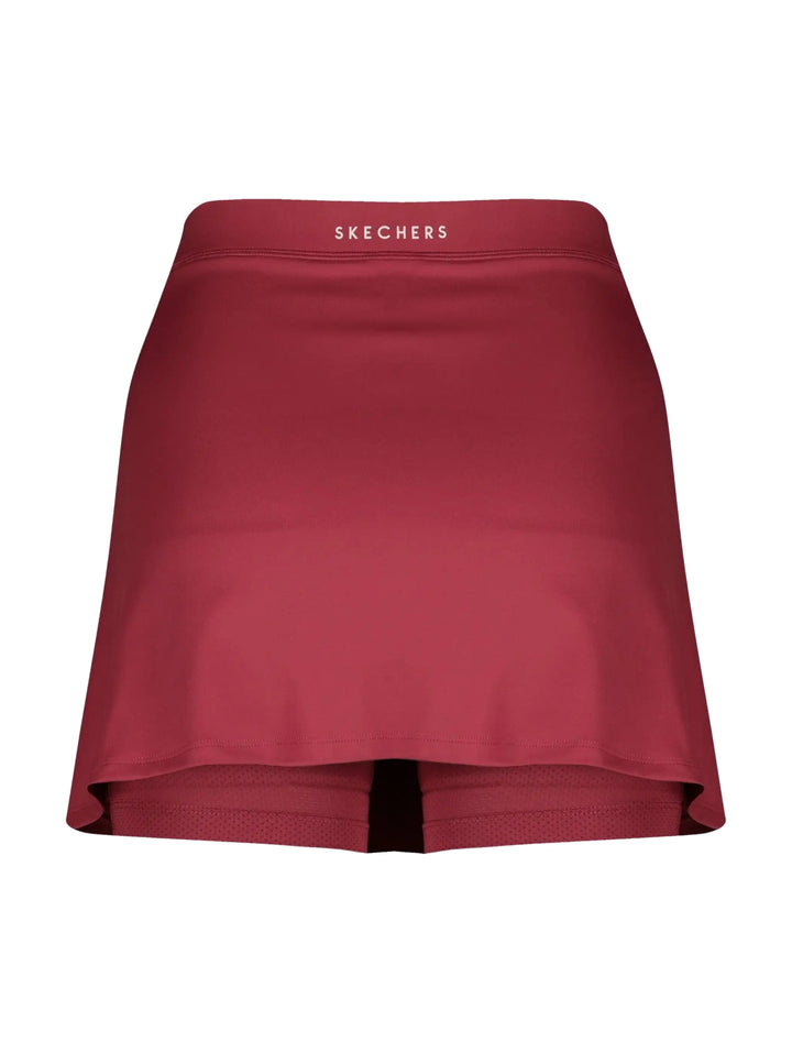 Mujer vistiendo una falda short deportiva de color rojo marca Skechers.