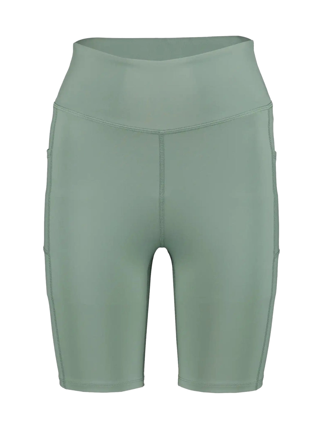 Mujer vistiendo biker shorts de color verde claro de cintura alta y calzado deportivo gris.